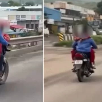 A woman from Pune is seated on the petrol tank of a motorcycle, hugs rider on busy road
